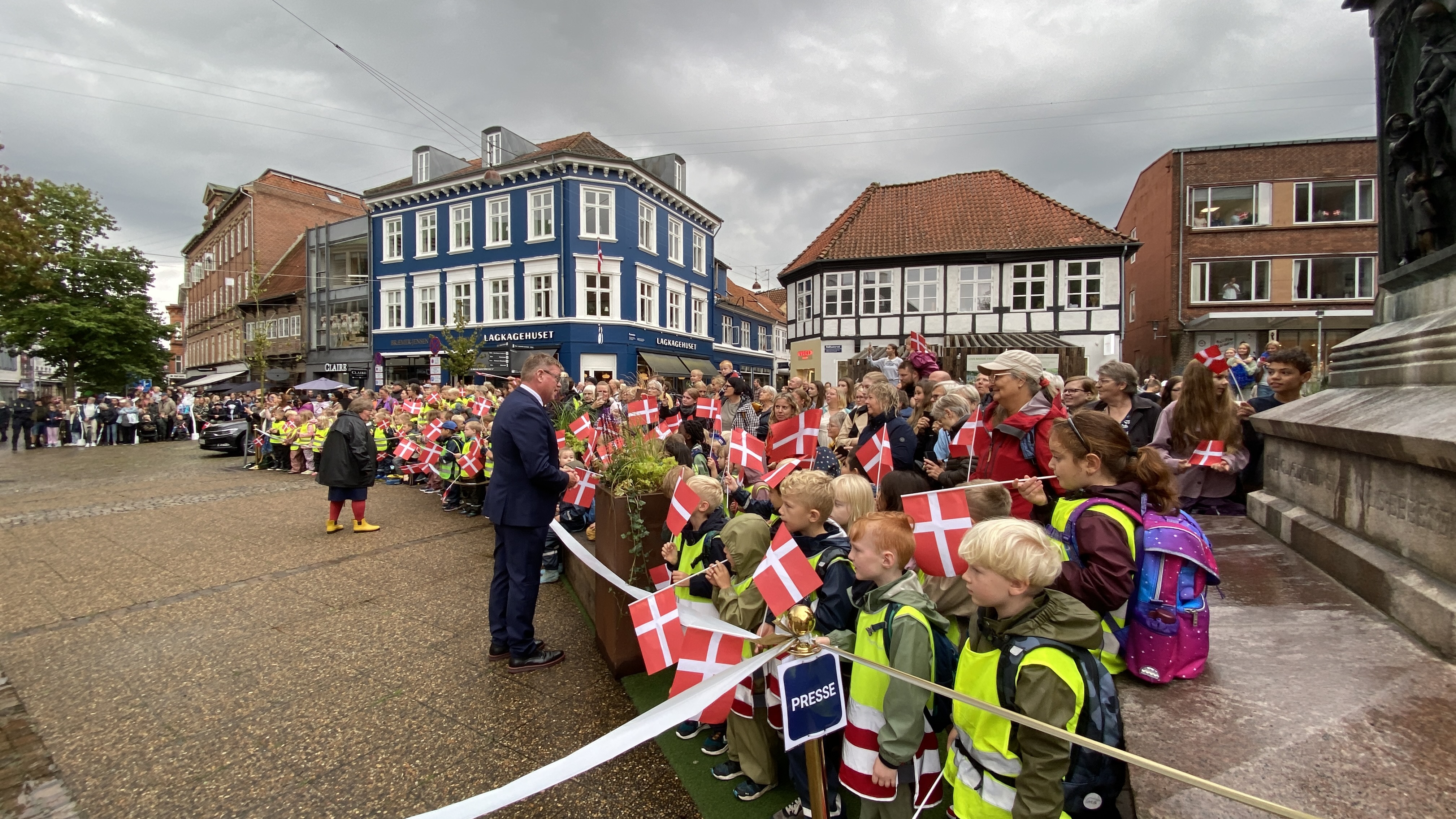 Borgmesteren hilser på folk, som står klar til at modtage Dronningen på Rådhustorvet.
