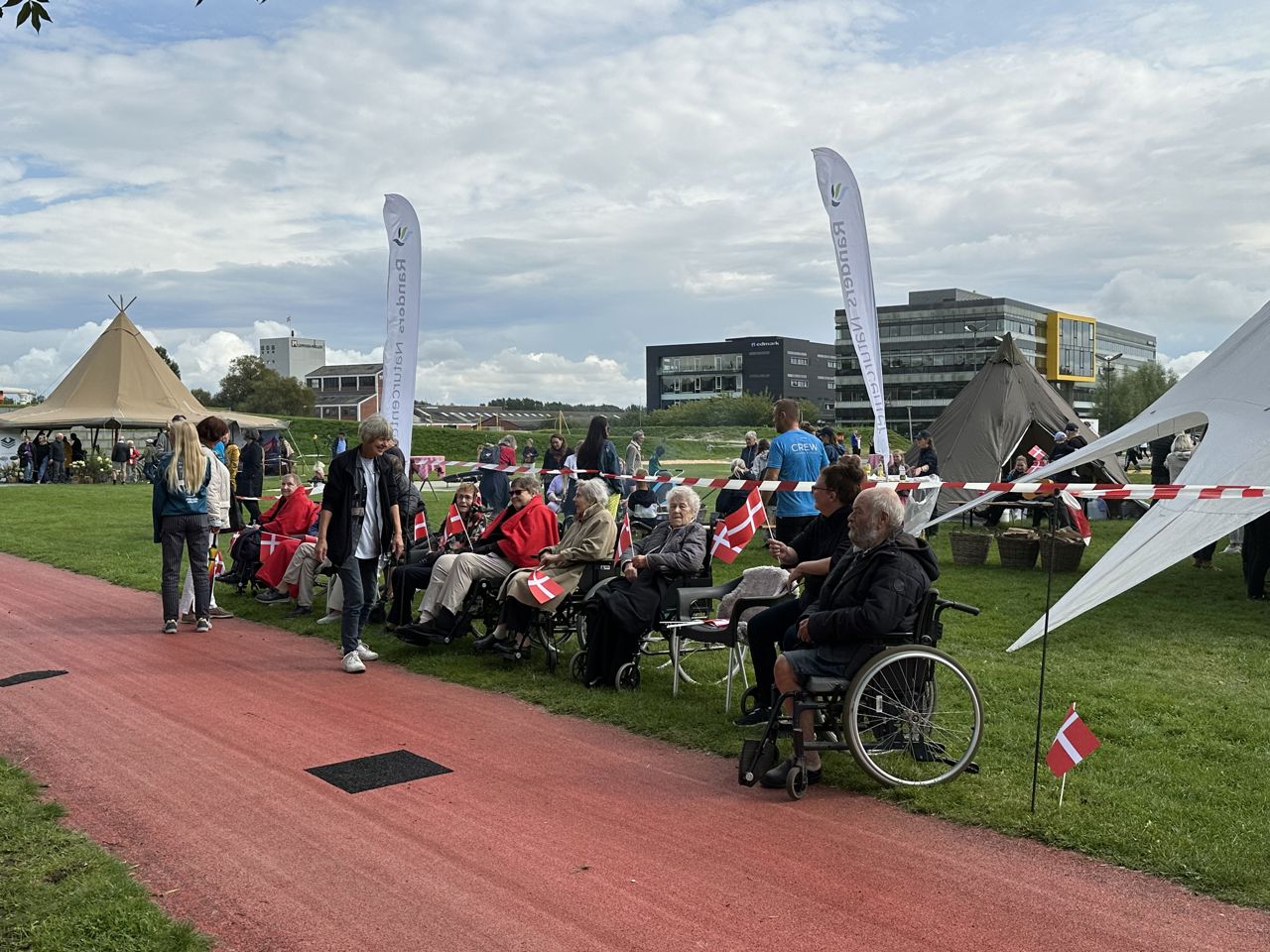 Folk er klar til at modtage Dronningen i Tronholmparken