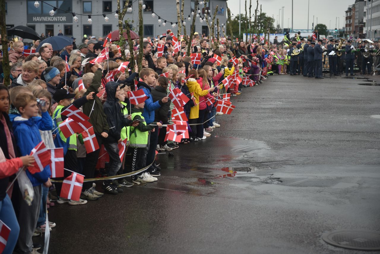 Folk står klar til at modtage Dronningen på havnen